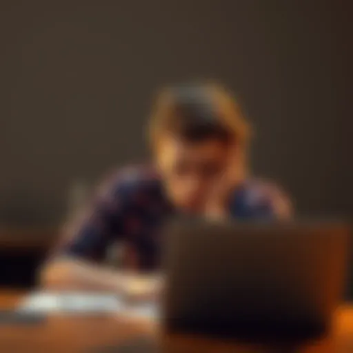 An 18-year-old man with a concerned expression sits at a desk with a laptop, holding his head in frustration after losing money in crypto trading.
